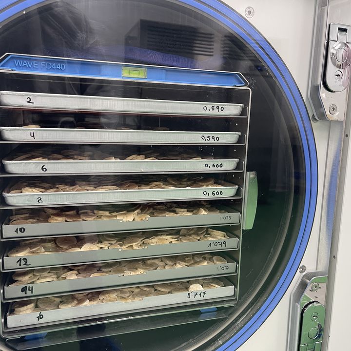 A freeze-dryer with its door open and trays loaded
